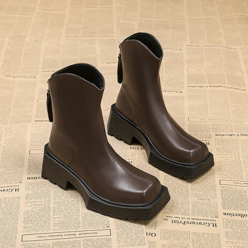 Black women's platform Martin ankle boots with a square toe and high heel on a white background