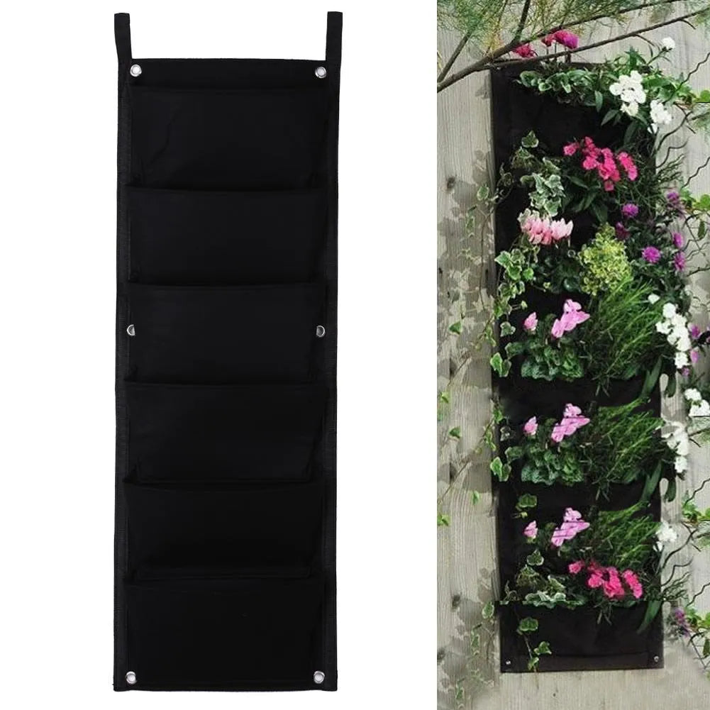 Green felt vertical wall planter with multiple planting pockets hanging on an outdoor wall