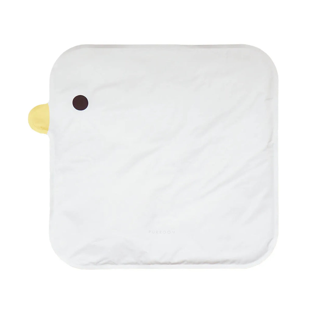 Yellow chick-shaped pet cooling mat on a wooden floor, showing non-stick fabric surface.