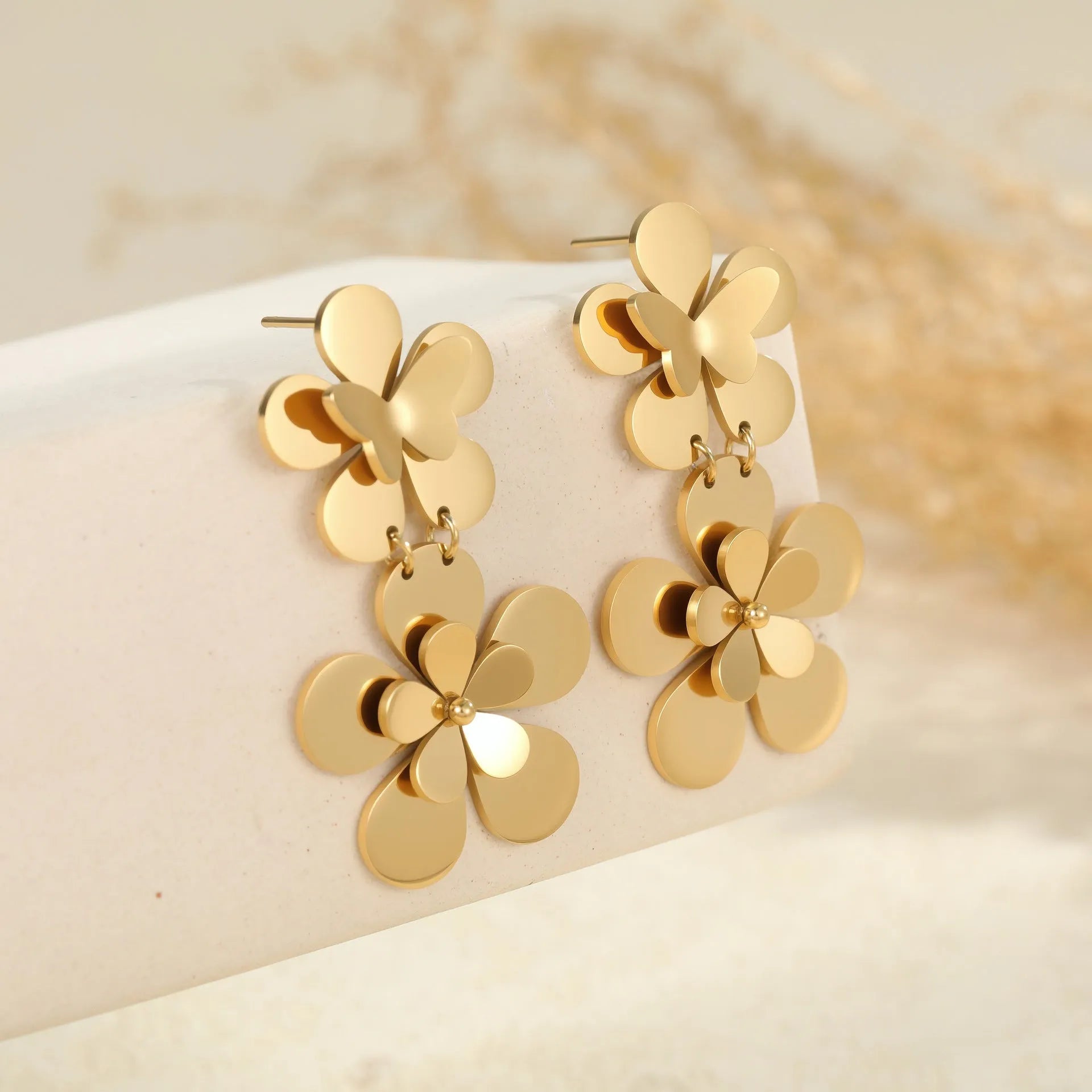 Gold-coloured flower butterfly earrings with geometric design elements on stainless steel