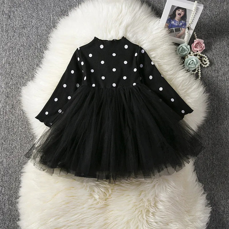 Baby girl in a long sleeve black lace tutu dress, suitable for christenings and parties.