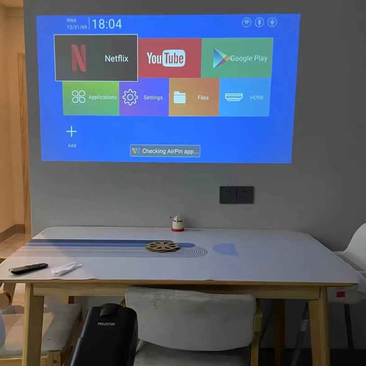 Home projector unit with carrying handle showing 720p HD and wireless projection features