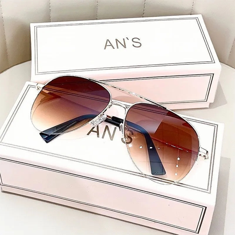 Aviator-style sunglasses with a metal frame and tinted resin lens, shown in a gold frame variant.