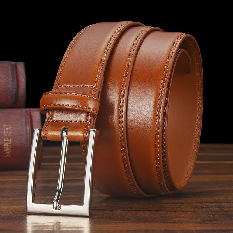 Men's black leather belt with a silver alloy pin buckle laid flat, showing its length and width.