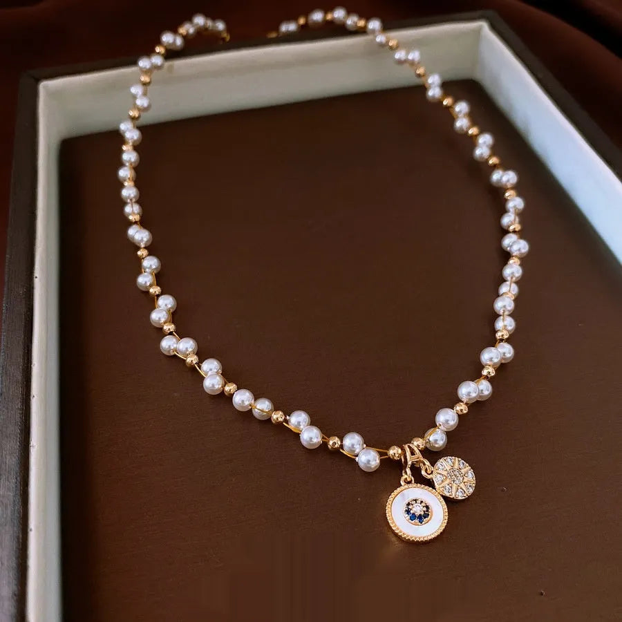 Golden-white electroplated necklace with round pearl pendant on adjustable clavicle chain