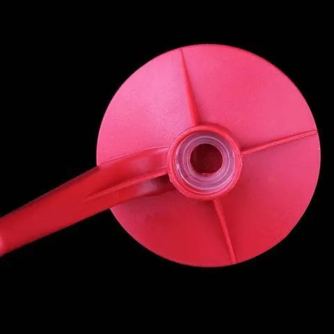 Red plastic Magic Tap soda drink dispenser for 2-litre bottles on a kitchen counter.