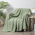 Soft cotton velvet jacquard sofa blanket in a solid colour draped over a modern sofa.