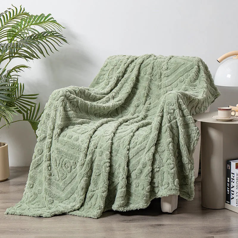Soft cotton velvet jacquard sofa blanket in a solid colour draped over a modern sofa.