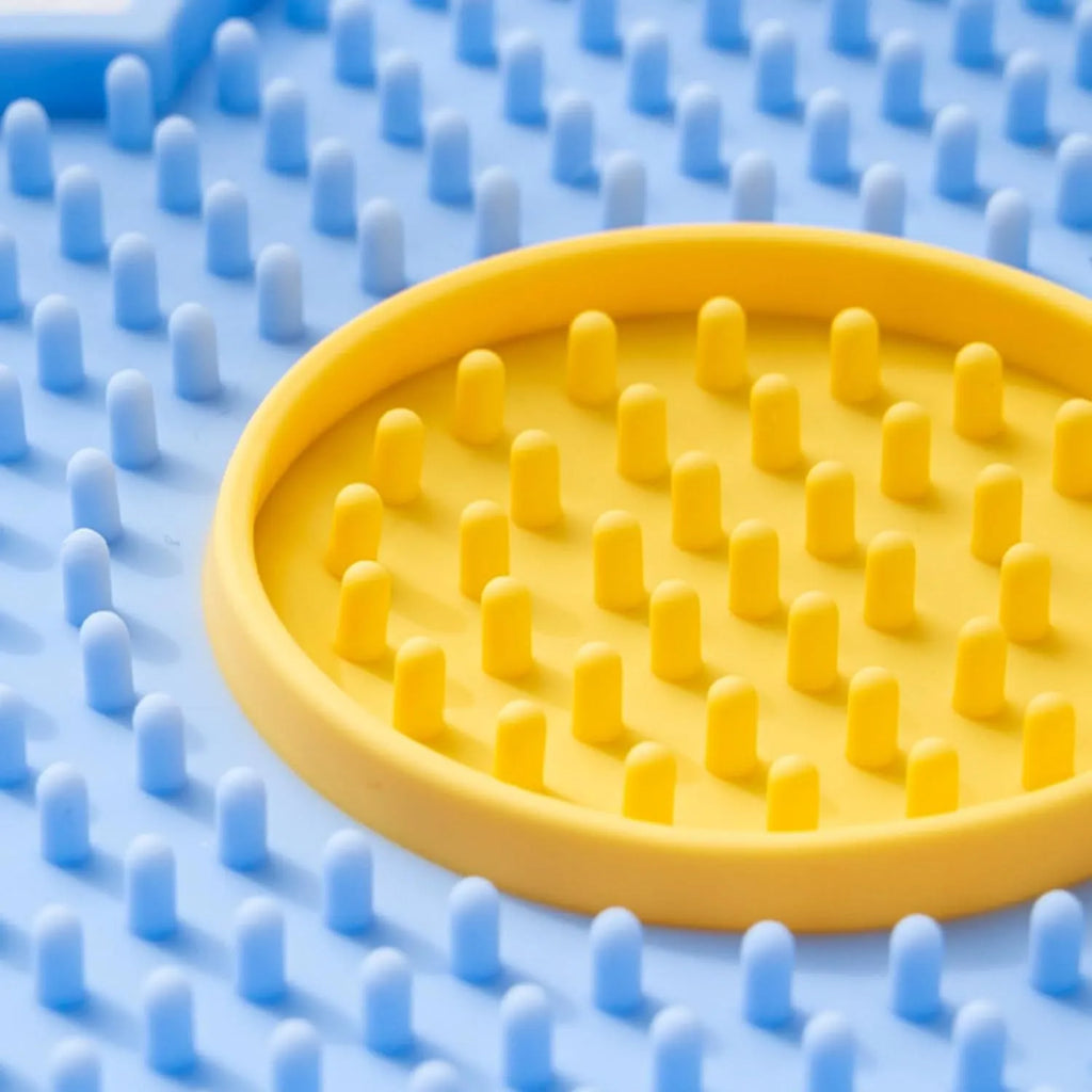 Flower-shaped silicone pet licking mat with suction cups in blue, grey, pink, purple, or red.