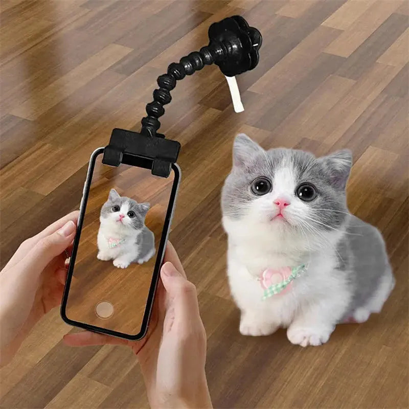 Black plastic pet photography clip holding a phone, with a rotating arm to grip dog or cat treats for photos.