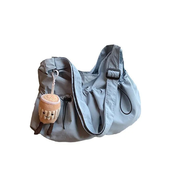 Green ultra-light pleated polyester crossbody bag showing split pocket and phone compartment.