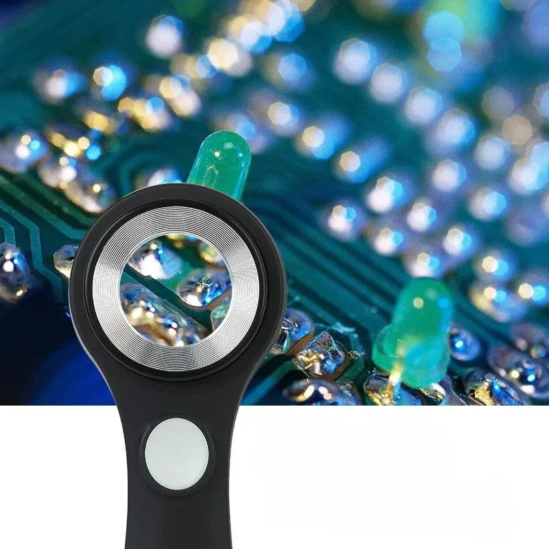Black and silver handheld appraisal magnifying glass with optical glass lens and USB-C cable on a table.