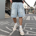 Light blue ripped denim shorts with distressed detailing and loose straight-leg silhouette