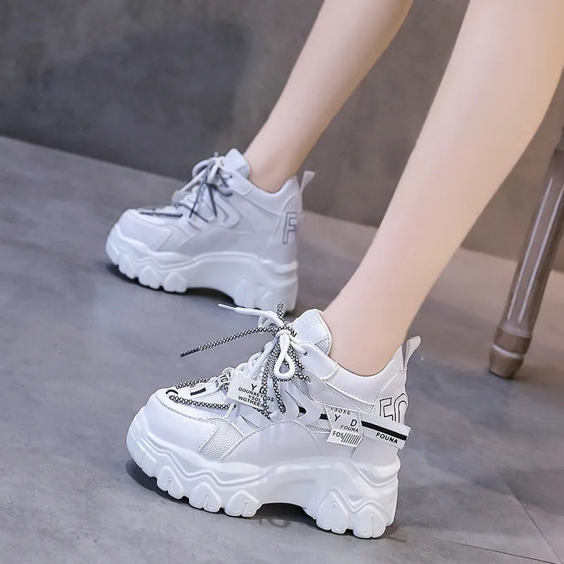 White women's low-top platform trainers with breathable mesh and a black cross-strap.
