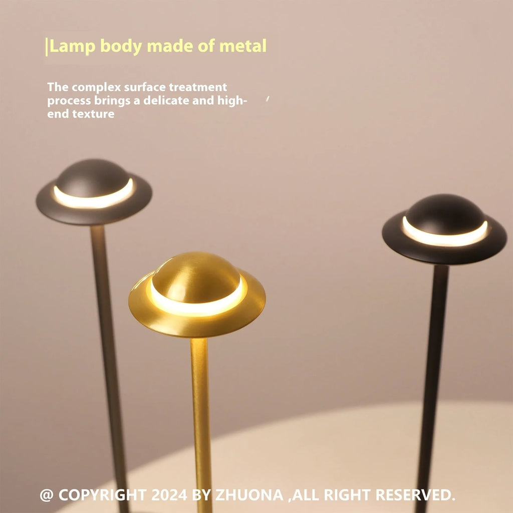 Modern UFO-shaped rechargeable table lamp in gold, grey, or black with touch dimming controls.