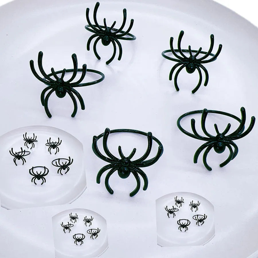 Six black spider-shaped alloy napkin rings for Halloween table decoration.