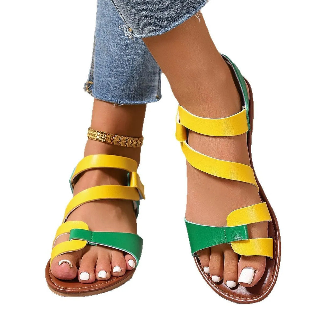 Women's black flat sandals with Velcro strap and round toe on a rubber sole.