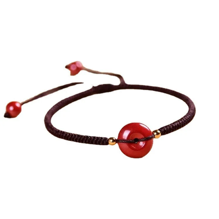 Heart-shaped cinnabar pendant on adjustable safety buckle bracelet with red cord