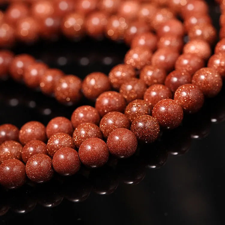 Golden star stone nugget bracelet with mantra beads and a retro fu charm on a wrist.