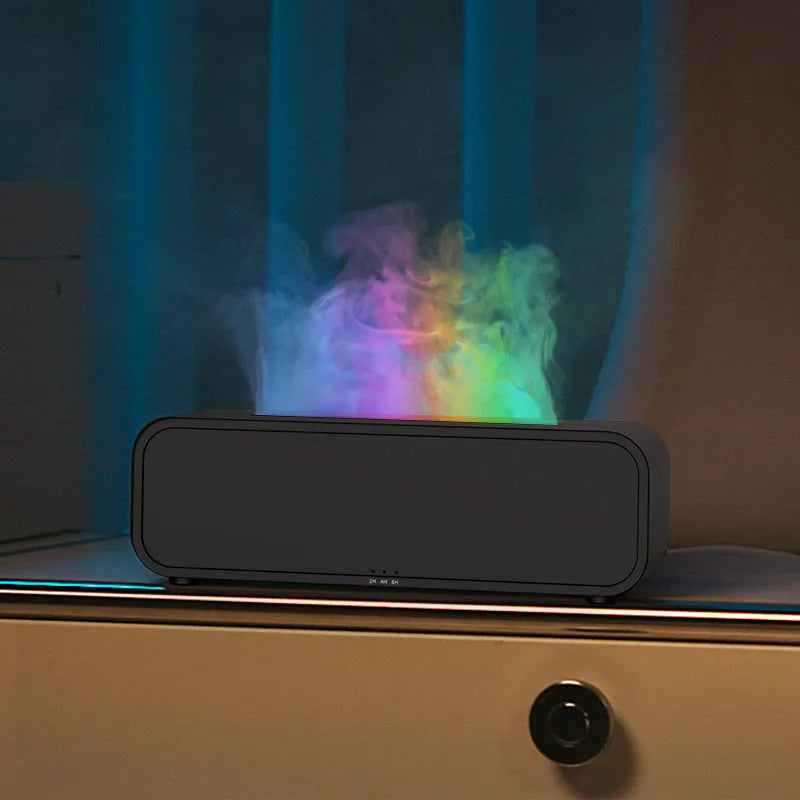 Black and white essential oil diffuser with flame effect and colour-changing lights next to remote control
