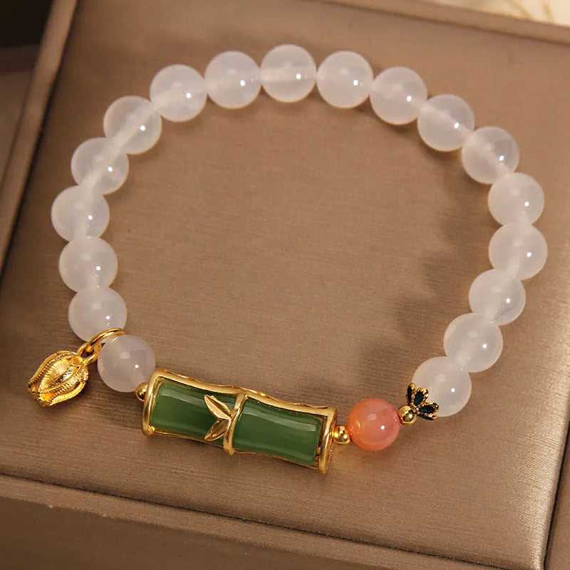 Close-up of a white agate and jade bamboo joint bracelet for women, traditional Chinese style.