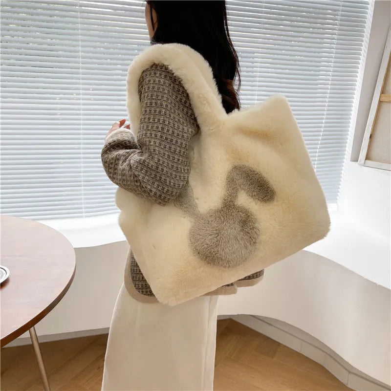 Plush shoulder bag with cartoon rabbit ears design in a solid colour.