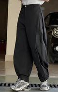 High-waisted pleated wide leg trousers in black, loose fit with elasticated waistband