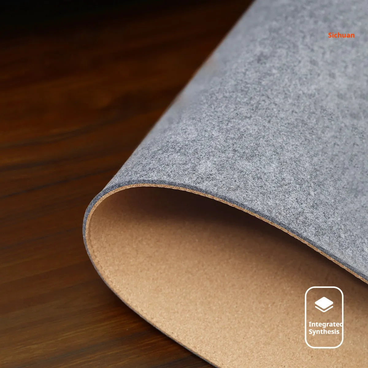 A winter warm felt cork office desk mat in a grey colour pattern, shown on a wooden desk with a mouse.