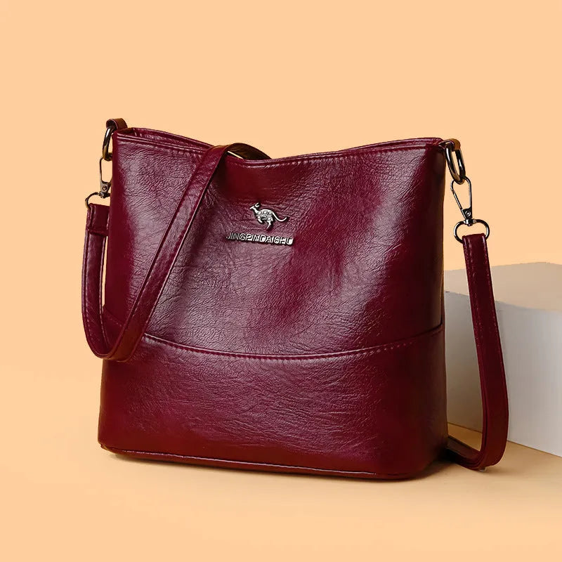 Women's soft leather bucket shoulder bag in black with minimalist design and interior phone pocket