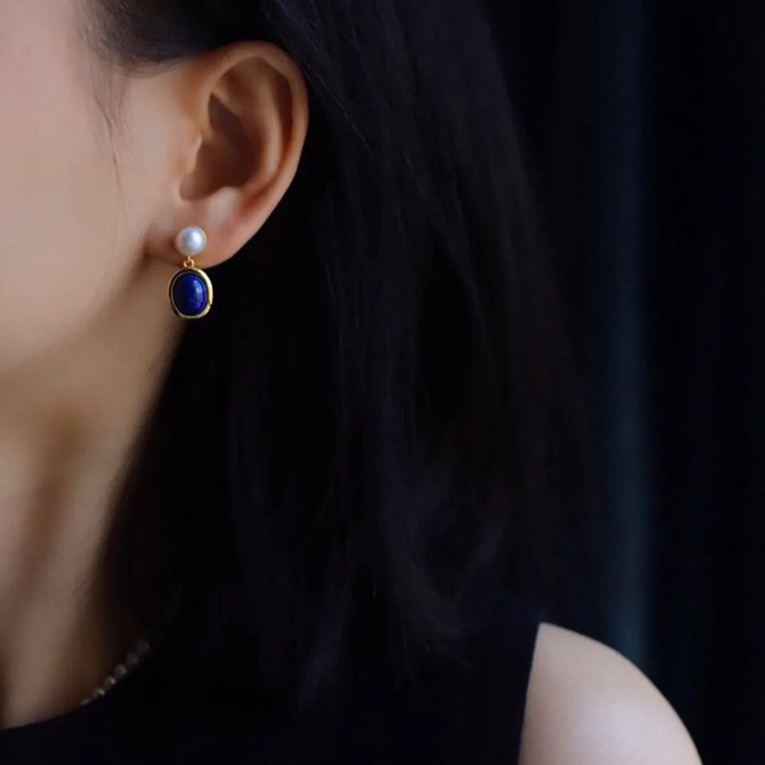 A pair of sterling silver earrings with deep blue lapis lazuli pearls and simple auspicious patterns.