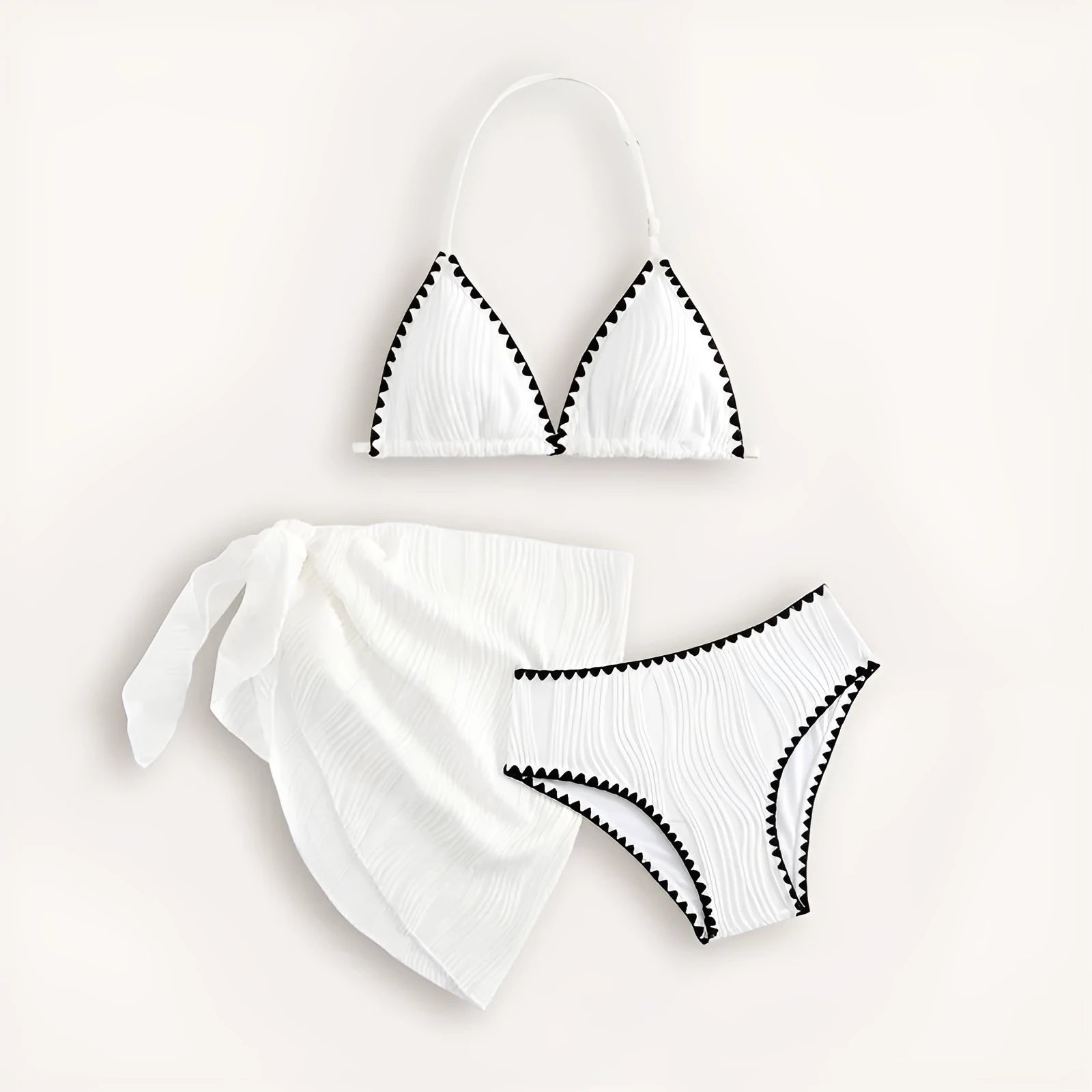 Solid white three-piece girls swimsuit set with top, pants, and skirt on a beach setting.