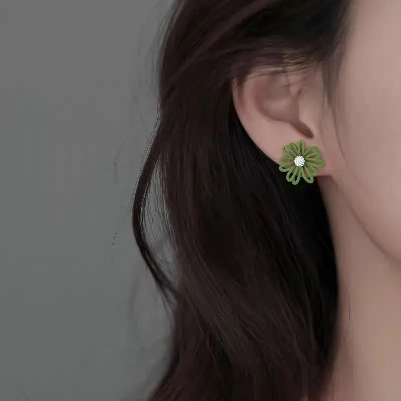 Three pairs of alloy flower earrings in blue-orange, white-green, and yellow-white colour combinations