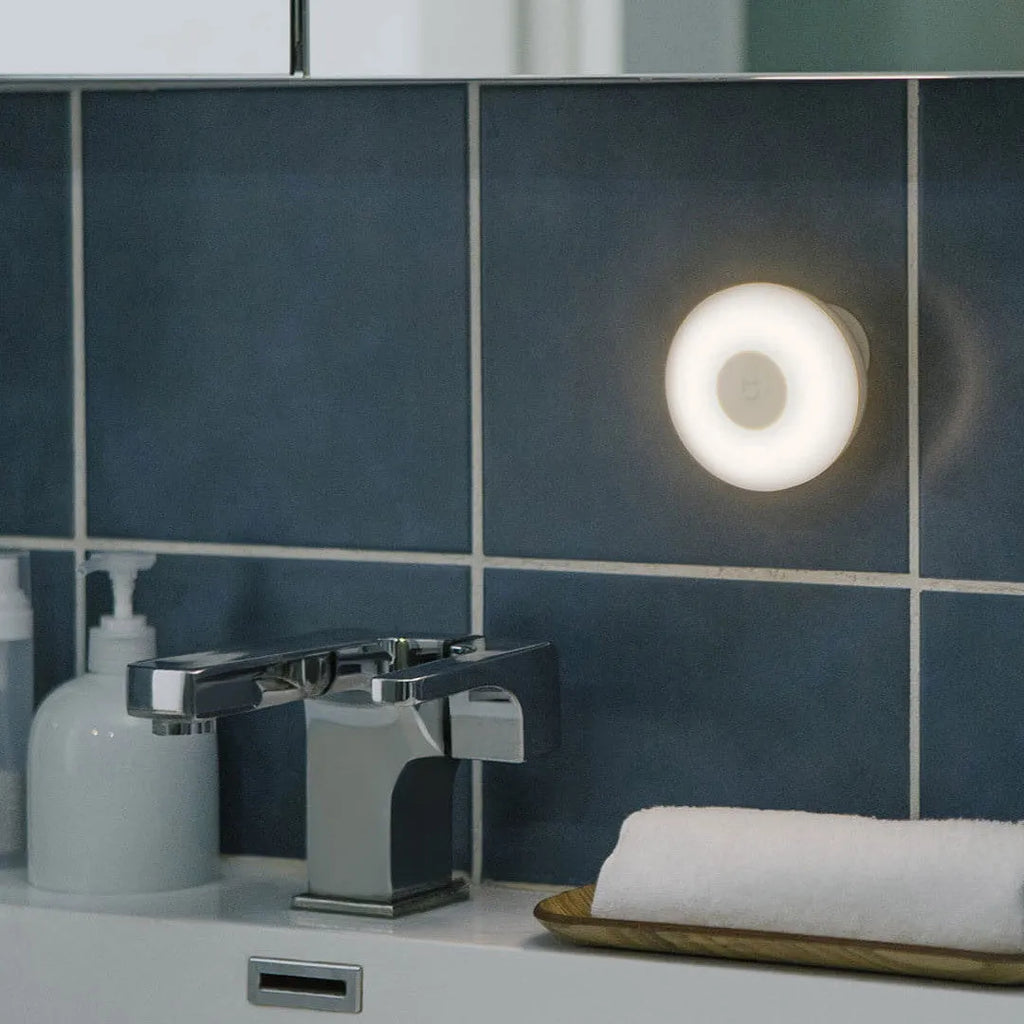 White modern Mijia induction bedside lamp with compact cubic design on a table.