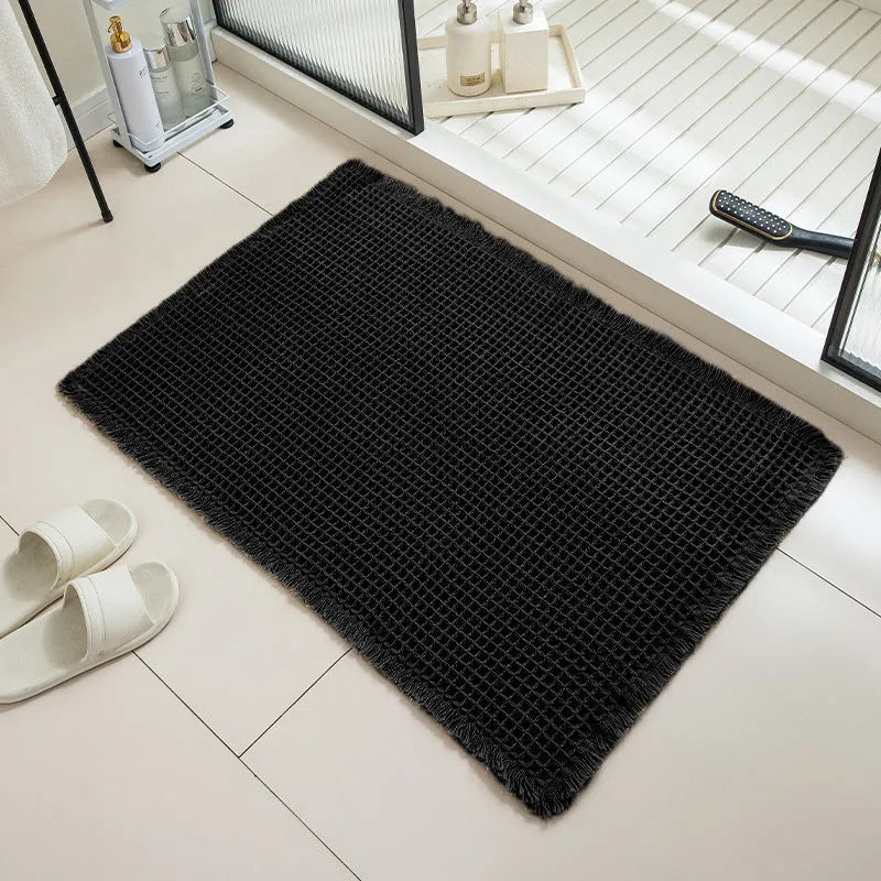 Checkered patterned non-slip absorbent bathroom floor mat in a neutral colour on tiles.