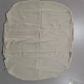 Beige portable baby nest crib cot for newborns on a neutral background.