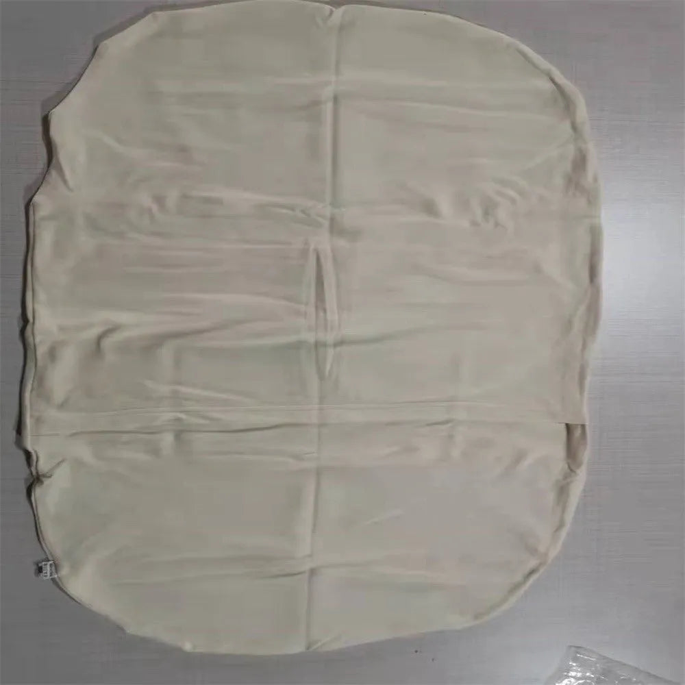 Beige portable baby nest crib cot for newborns on a neutral background.