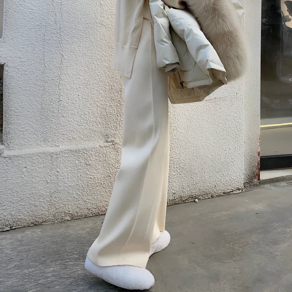 Women's high-waist knitted wide-leg trousers in cream white, showing straight-leg cut and drooping hem.