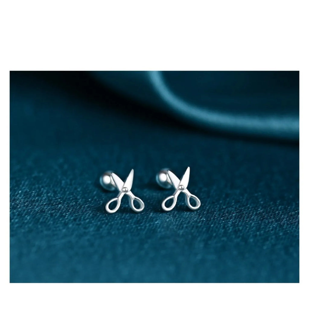 A pair of pure silver screw style ear nails with a miniature scissors design