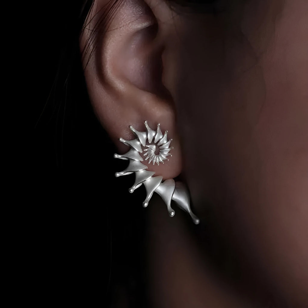 Exaggerated three-dimensional matte conch stud earrings with an irregular alloy design.