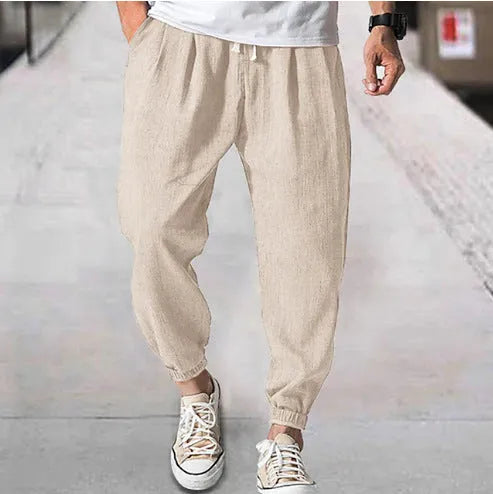 Man wearing light-coloured cotton banded ankle pants with a loose, casual fit.