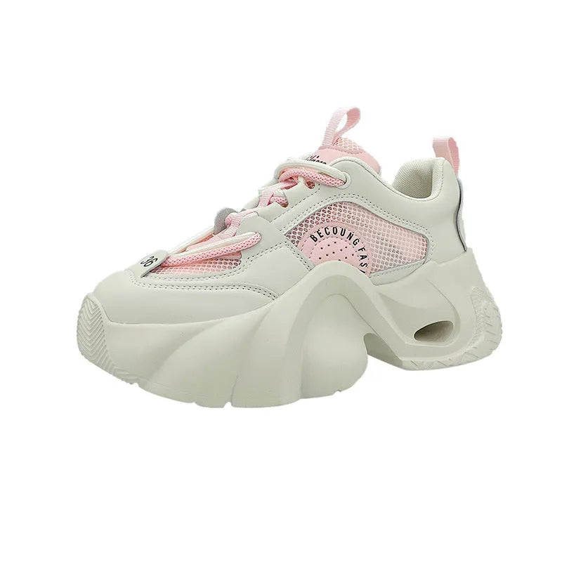 Women's pink sneakers with cross shoulder straps, thick sole, and mesh lining on a white background.