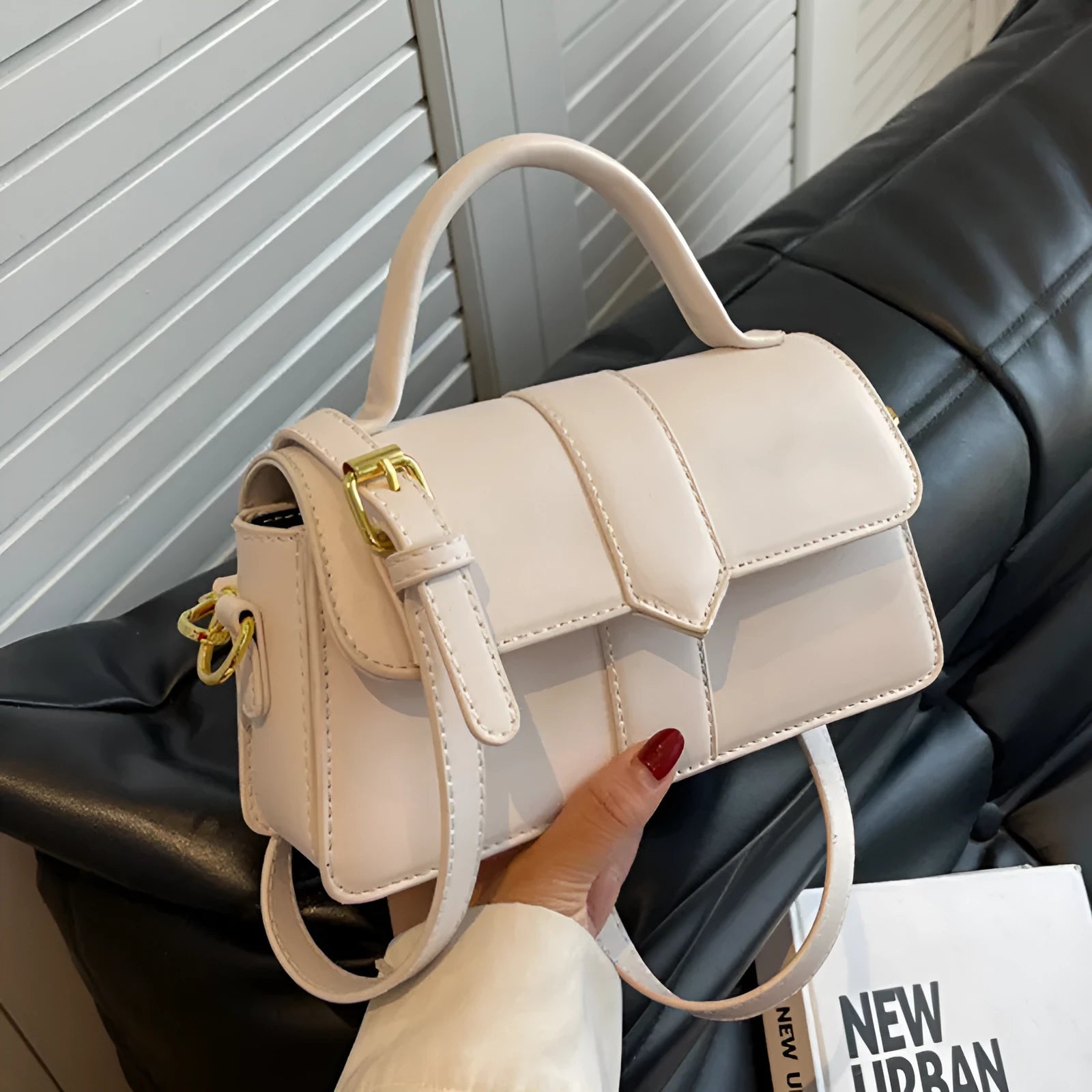 Women's beige messenger bag with adjustable strap showing internal file compartment and outer sandwich pocket