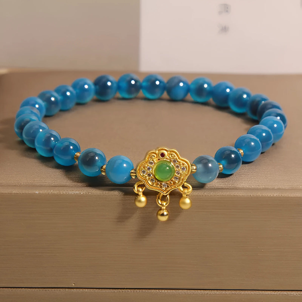 Close-up of a women's blue sugar heart agate safety lock pendant bracelet with crystal links and rhinestone detailing.