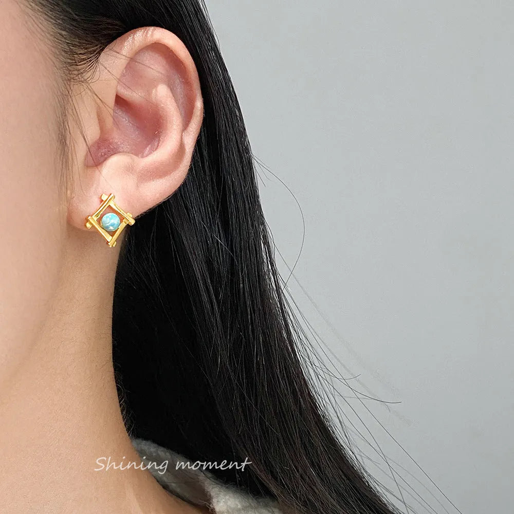 Women's geometric cross-shaped quadrangle stud earrings in sterling silver on a white background.