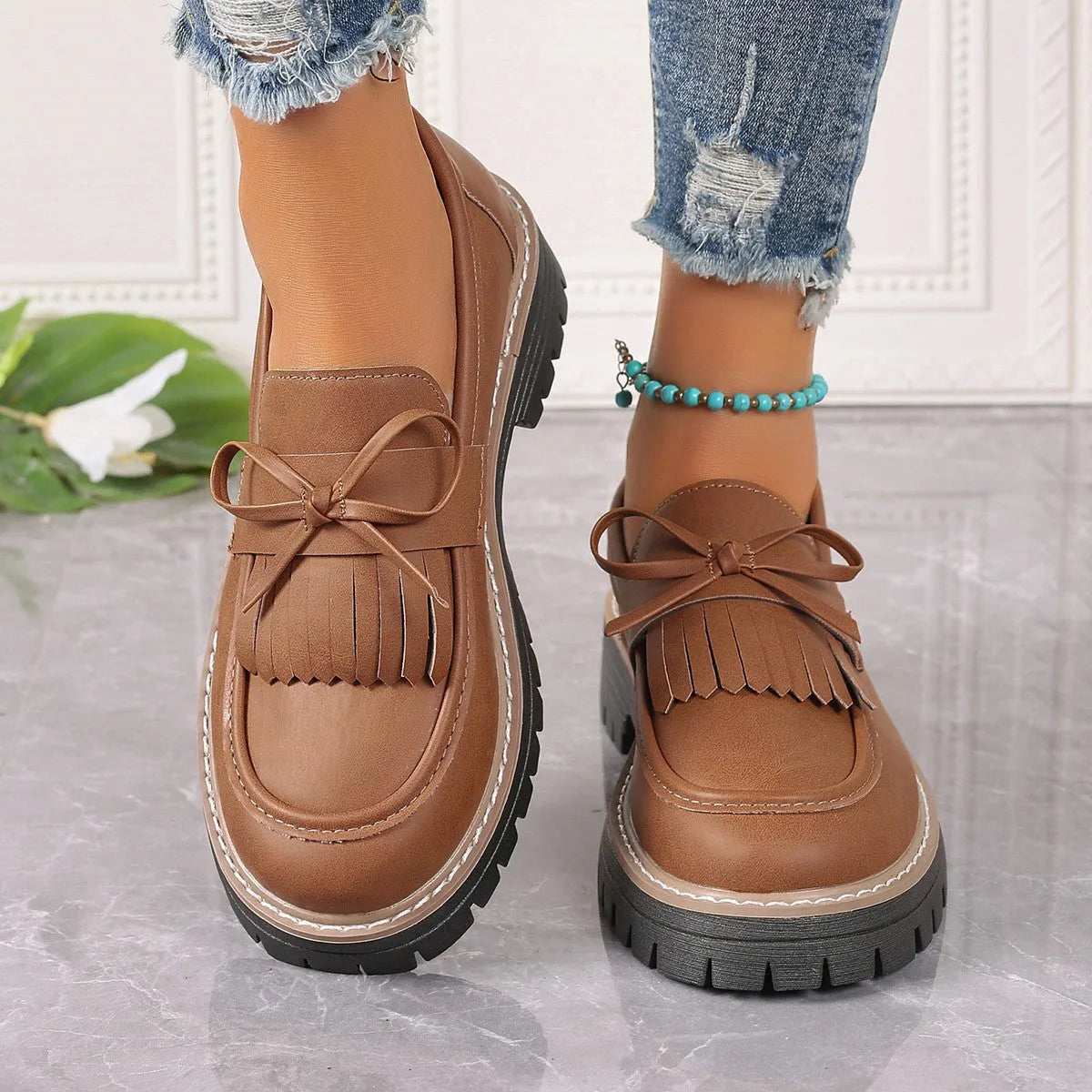 Women's black plus size loafer with tassel and bow decoration on a chunky rubber sole