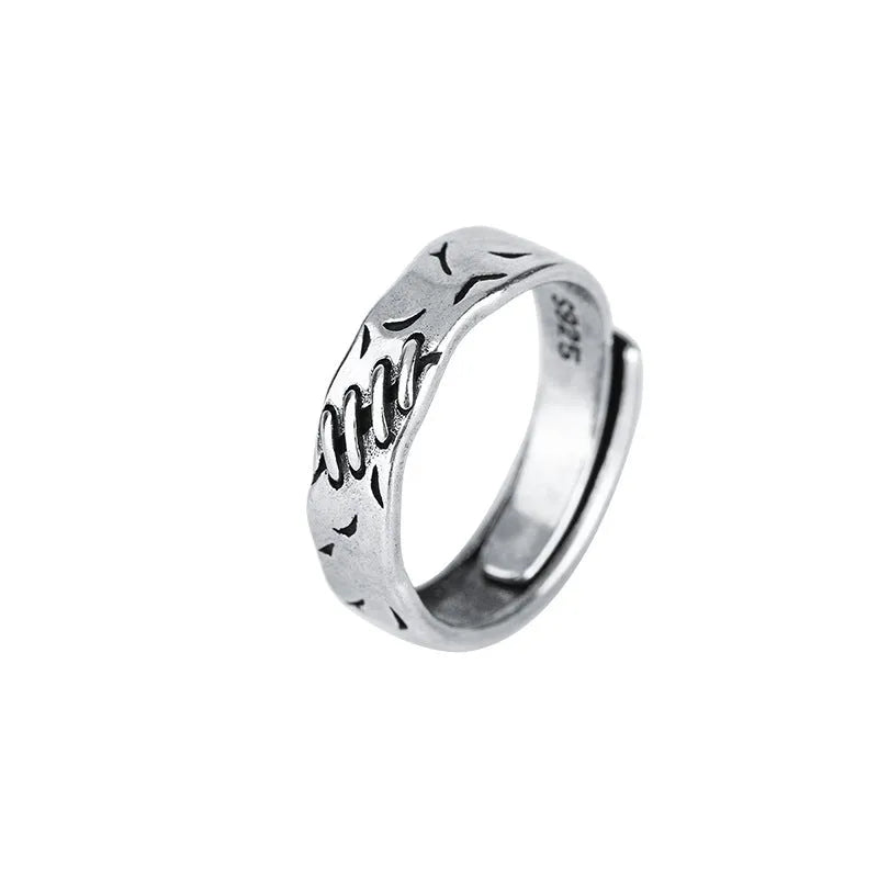Black geometric copper ring with adjustable opening, showing round and oval design elements