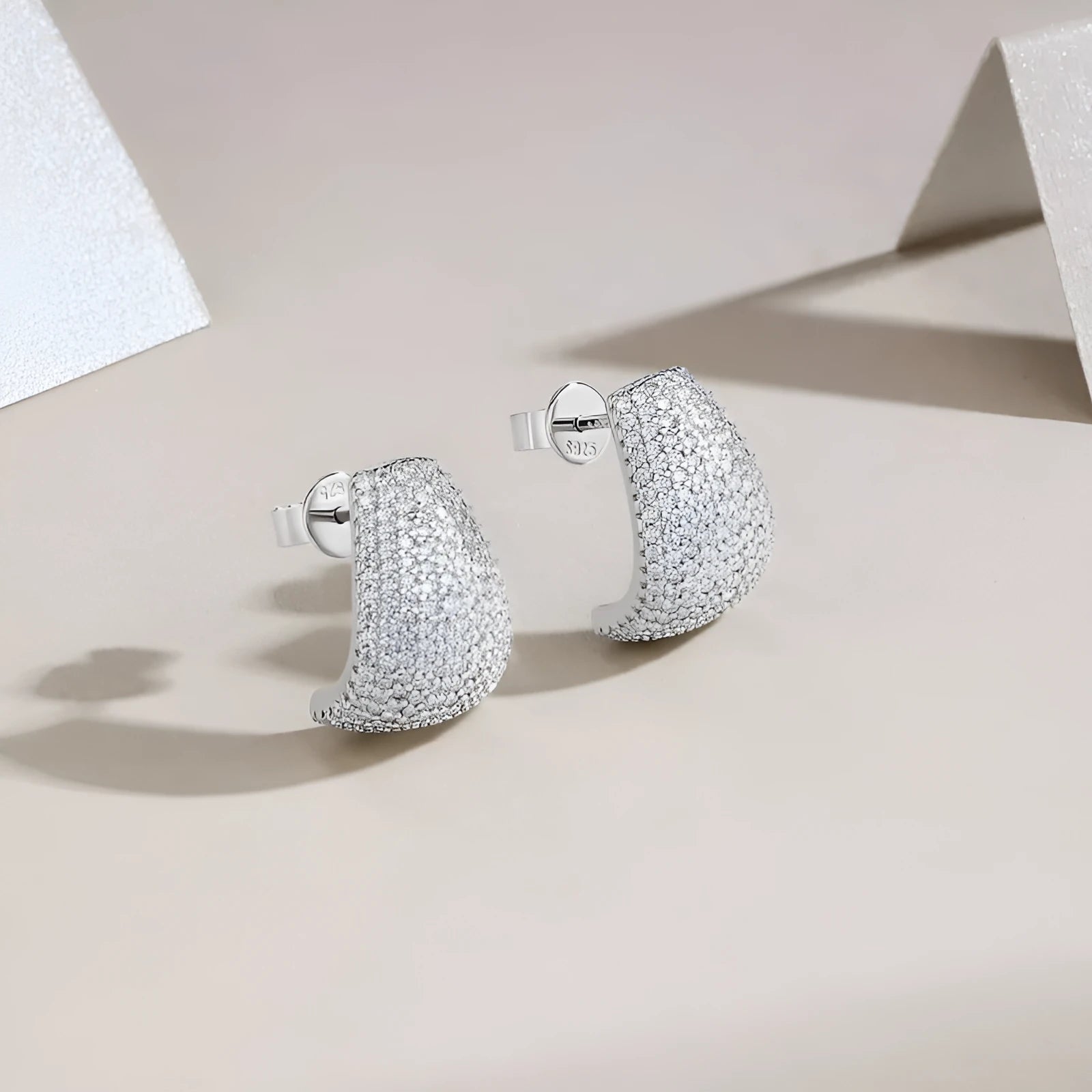 A pair of geometric sterling silver ear studs with moissanite stones for women.