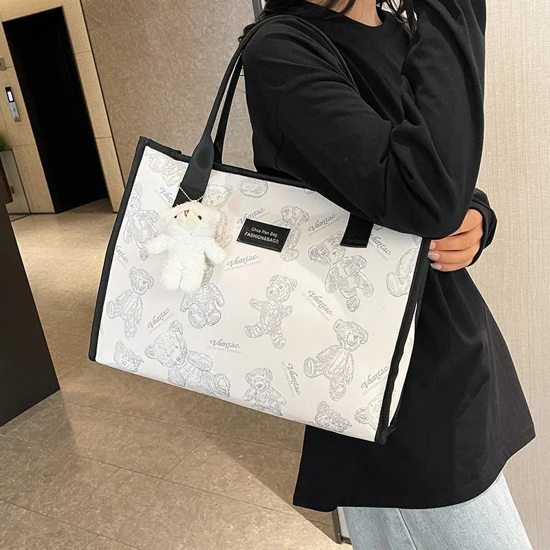 Women's black and white canvas tote bag with diamond pattern and sandwich pocket
