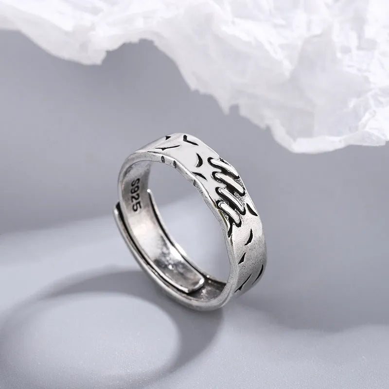 Black geometric copper ring with adjustable opening, showing round and oval design elements