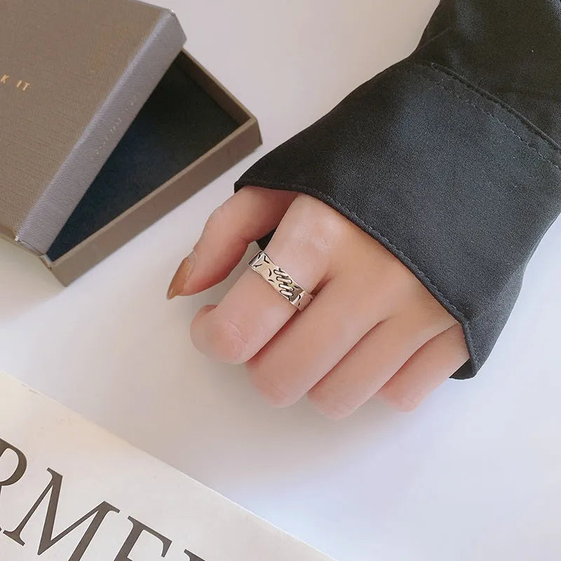 Black geometric copper ring with adjustable opening, showing round and oval design elements
